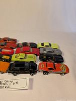 Top-down view of 17 diecast hot rod cars in multiple colors lined up in rows