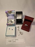 Photo showing the collection of jewelry items including rings, earrings, and necklaces in their boxes and containers.