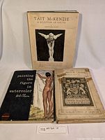 Lot of three art books displayed upright including 'Tait McKenzie: A Sculptor of Youth', 'Painting the Figure in Watercolor', and 'The Fine Arts in Canada' with a visible price tag and label '115 Art Book Lot'.