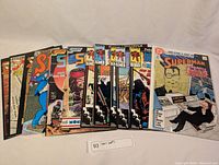 Front view of all comics fanned out to show covers, including Superman and others