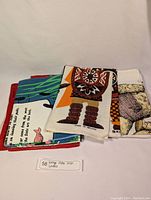 View of folded group of vintage linens showing colorful graphic prints and tags