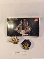 Gold plated Minicraft H.M.S. Bounty ship model in original box, resin ship model and blue resin ship art piece.