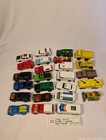 Top-down view showing all 25 diecast toy vehicles arranged in five rows on white background, with a note indicating 25 vintage cars from Hot Wheels, Ertl, Lesney, Majorette from the 1960s-1980s.
