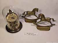 Full view of the vintage Kern dome clock alongside two brass horse bookends.