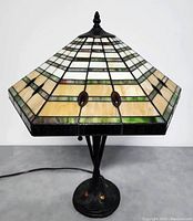 Full view of the Tiffany style table lamp showing stained glass shade and metal base.