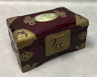 Full angled view of the antique Chinese jewelry box highlighting the carved inlaid stone medallion on the lid and brass hardware accents.