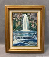 Frontal view of the framed waterfall painting showing the entire artwork and frame.