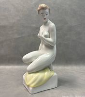 Front view of the vintage Hollohaza porcelain figurine showing kneeling female figure with painted features.
