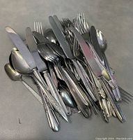 Photo showing the pile of assorted vintage cutlery including knives, forks, and spoons with varied handle designs.