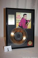Framed gold plated record with Elvis Presley album cover and plaque inside a black frame, shown from front.