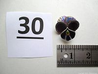 Top view of the vintage Alice Caviness pansy brooch next to a ruler showing size approximately 1.25 inches square.