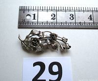 Top view of vintage Danecraft sterling silver rose brooch with metal ruler for size reference showing length approximately 2.7 inches.