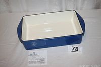 Blue and white enameled cast iron roaster with side handles, white interior and blue exterior.