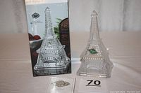 Lead crystal Eiffel Tower jewelry/trinket box next to its original packaging and certificate, showing the entire item in upright position with box behind it.
