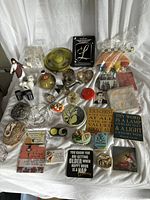 Photo showing various religious plaques, jars, figurines, and novelty items arranged on a white cloth background.