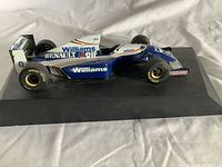 Side view of the Williams Renault F1 scale model car showing sponsor logos and details on a black base.