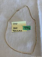 Full view of gold chain laid out with weight and karat noted on sticky note
