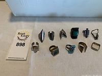 All 11 metal rings displayed on flat surface with auction tag