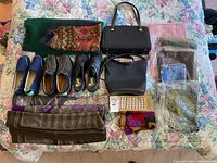 Full spread of shoes, purses, and scarves arranged on floral bedspread showing product variety.