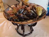 Blue and white porcelain bowl on rosewood stand filled with assorted stone fruits