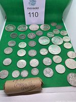 Wide shot showing sealed roll and all loose coins on green background