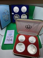 Overview of two presentation cases (red and blue) each holding four encapsulated coins