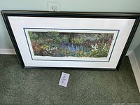 Full view of the framed print titled 'Boundless' showing a dense garden landscape in vibrant colors with a black frame and double matting.