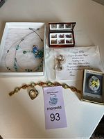 Full display of jewelry lot with bracelet, pin, necklace, ring collection and box