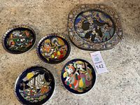 All five decorative plates arranged on floor, visible detailed designs and large plate size