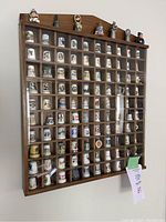 Full view of wooden display rack holding approx 60 collectible thimbles.