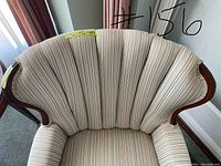Overhead angled view focusing on the curved shell shape backrest and vertical striped upholstery pattern, with label showing dimensions.