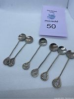 Photo showing all 6 coffee spoons metal crafted with coin bowls and decorative twisted handles with teardrop ends.