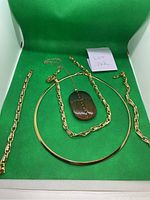 Photo showing all four jewelry pieces including two bracelets, a choker, and pendant necklace with Givenchy cross