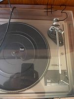 Close-up of the Dual 505 turntable showing the platter, tonearm, and lid with crack.