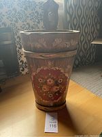 Front view of wooden umbrella holder showing handpainted floral design and decorative scrollwork