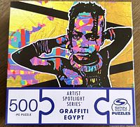 Front view of the puzzle box showing the colorful 'Graffiti Egypt' image and key product details including piece count and series name.