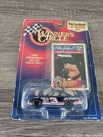 Front view of the die-cast car in blister packaging showing the number 3 car and collector card with Dale Earnhardt's image.