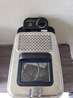 Top view of T-Fal deep fryer showing control dial and ventilation holes on the lid with viewing window.