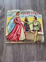 Photo of vintage Disney Cinderella musical story record sleeve showing artwork of Cinderella and prince with castle in background. Sleeve shows wear.