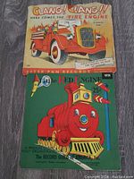 Photo showing two vintage children's 78 RPM records from Peter Pan Records: Clang! Clang!! and The Red Engine, laid flat on wood floor.