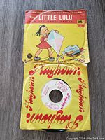Photo showing a Marge's Little Lulu Golden Record cover with Little Lulu illustration and Playhour record sleeve with visible wear.