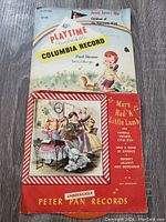 Photo displaying three vintage unbreakable children's records with illustrated sleeves, including Playtime Columbia record and Peter Pan records.