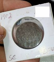 Photo of the reverse side of the coin showing the denomination "ONE CENT" and the date 1902 within a wreath.