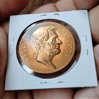 Front side of bronze Abraham Lincoln medallion showing profile and name inscriptions.