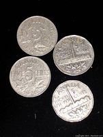 Top-down photo showing four Canadian 5 cent coins, arranged in a loose cluster on a black background; details such as dates and maple leaves are visible.
