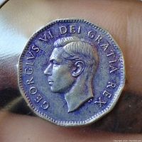 Obverse close-up showing King George VI profile and blue-purple toning around the edges of the nickel.