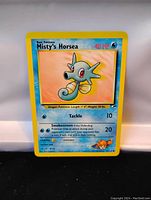 Photo of Misty's Horsea Pokemon Card with blue and yellow border, featuring the cartoon image of Horsea and card details.