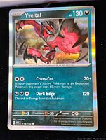 Close-up image of the Yveltal foil Pokémon card showing card details, artwork, and attacks