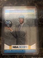 Front of the 2012 NBA Hoops rookie card showing Anthony Davis in New Orleans Hornets suit and cap holding a basketball.