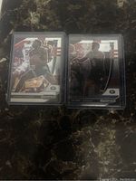 Two Anthony Edwards NBA rookie Prizm basketball cards in protective cases shown side by side on a dark surface.